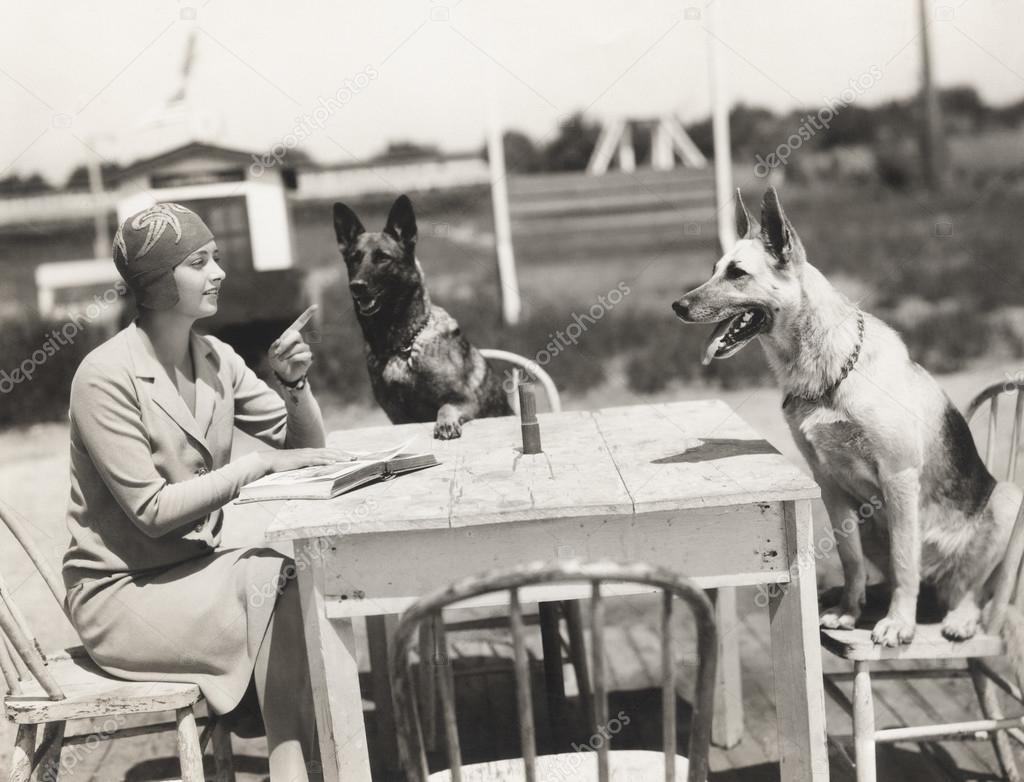 woman sitting at table with dogs