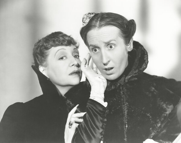 two woman whispering