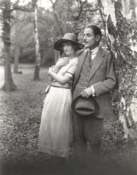 Man and woman standing by tree — Stock Photo, Image