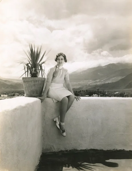Žena sedí na venkovní římse — Stock fotografie