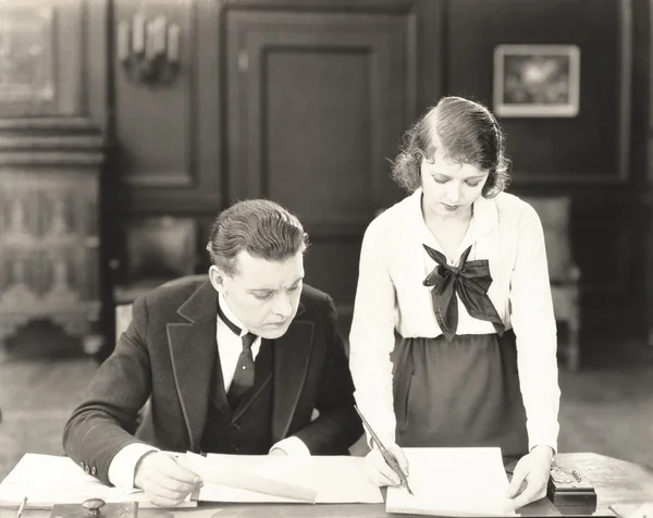 Чоловік і жінка працюють в офісі Стокова Картинка