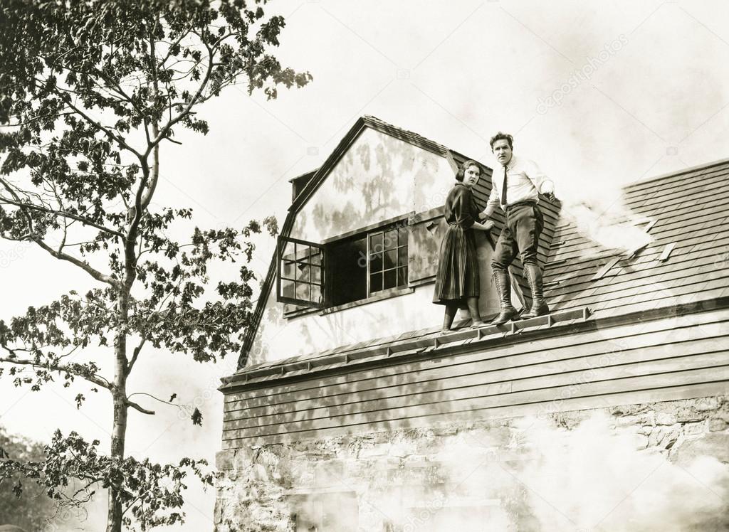 man and woman standing on roof