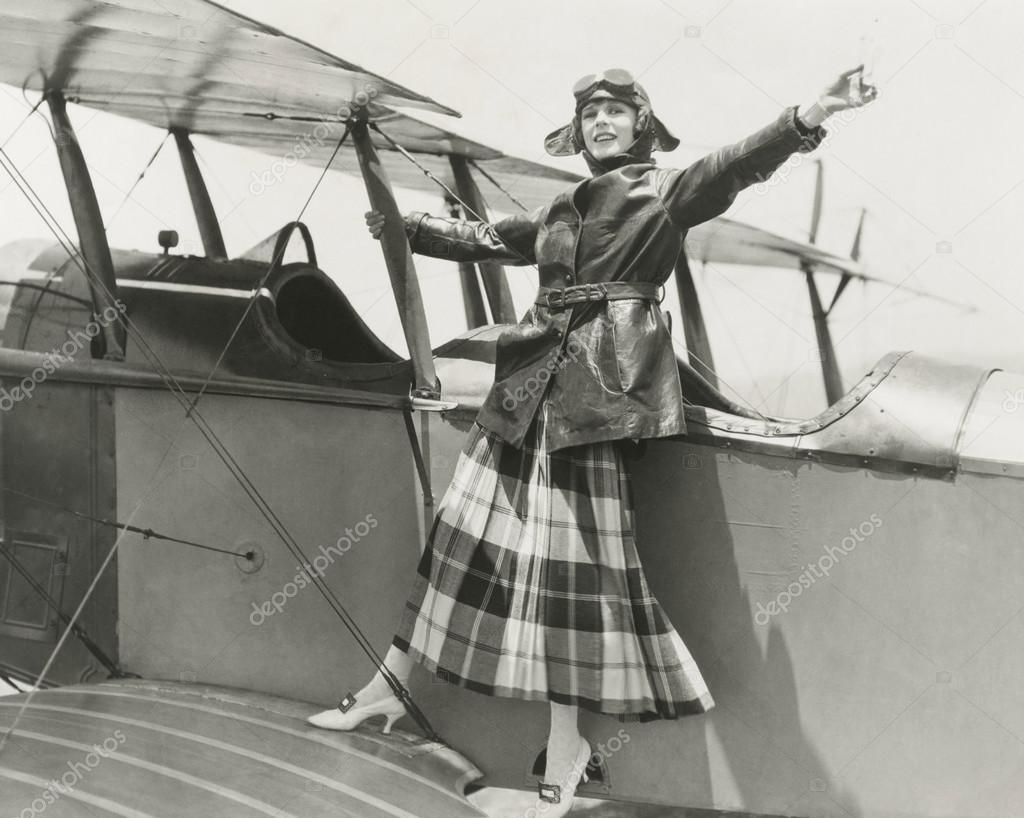 Aviatrix standing on bi-plane