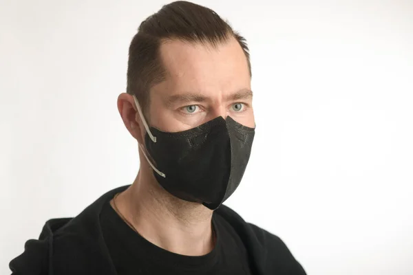 Un hombre con una máscara facial negra nano FFP2 —  Fotos de Stock
