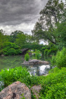 Yazın bulutlu bir günde Central Park 'taki Gapstow Köprüsü