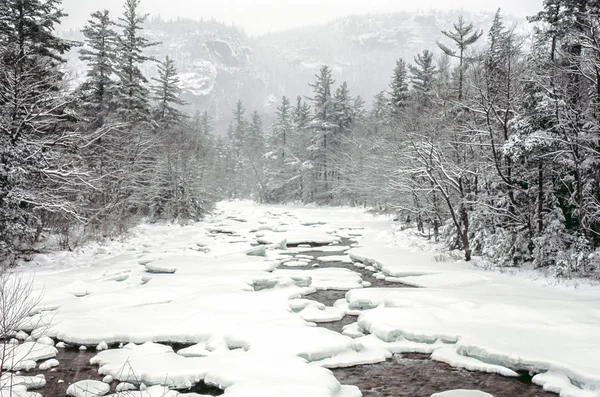 Sneeuwstorm op snelle rivier — Stockfoto