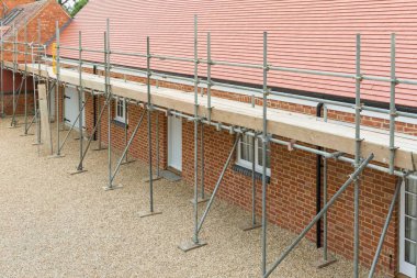Scaffolding outside a UK house extension, barn conversion to single storey bungalow clipart