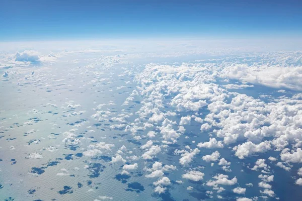 Atlantic ocean aerial view with blue sky, horizon and fluffy white clouds