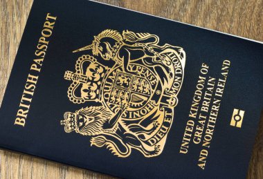 BUCKINGHAM, İngiltere - 25 Ekim 2020. Yeni mavi İngiliz pasaport kılıfı. Brexit sonrası İngiltere pasaportunun biyometrik sembollü kapanışı