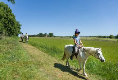 BUCKINGHAM, İngiltere - 25 Mayıs 2020. Stowe House, Stowe, Buckinghamshire yakınlarındaki kırsalda ata binen bir kız.