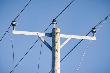 Elektrik şebekeleri kapanıyor, mavi gökyüzüne karşı elektrik hatları kesiliyor.