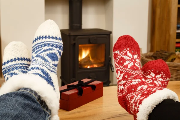 Christmas couple feet in front of fire — Stockfoto