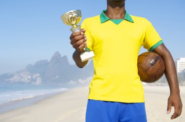 Champion Brazilian Footballer Holding Trophy and Soccer Ball clipart