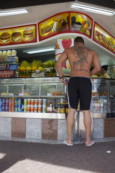 Soporte de jugo brasileño con cliente tatuado —  Fotos de Stock