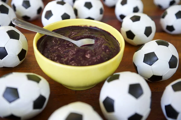 Bolas de fútbol y Acai en la mesa de madera Imágenes de stock libres de derechos