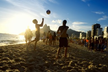 Gün batımı siluetleri Rio 'da Altinho Futebol Sahili Futbolu oynuyor