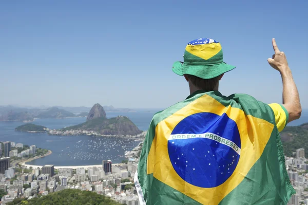 Patriotischer brasilianischer Fan steht in brasilianische Fahne gehüllt in Rio — Stockfoto