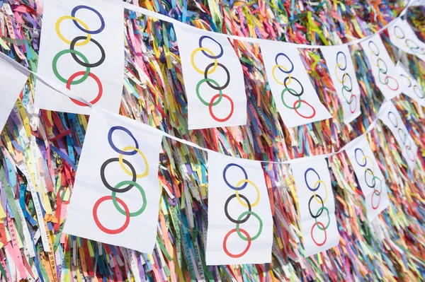 Olympiske flag bunting hængende foran brasilianske ønske bånd - Stock-foto