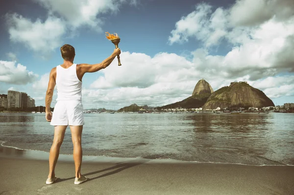 Молодой человек держит спортивный факел Рио-де-Жанейро — стоковое фото