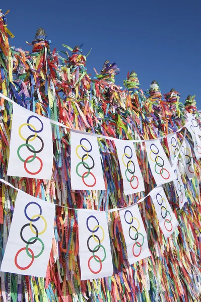 Olympiska flaggan Bunting hängande framför brasilianska önskar band — Stockfoto