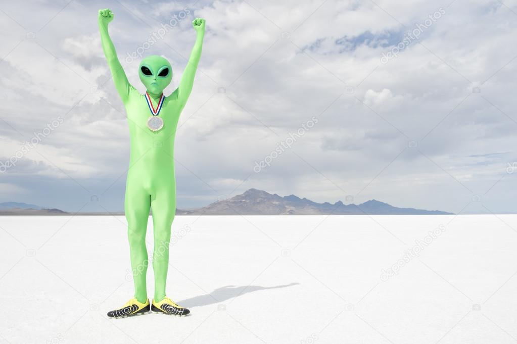 Gold Medal Green Alien Standing on White Planet