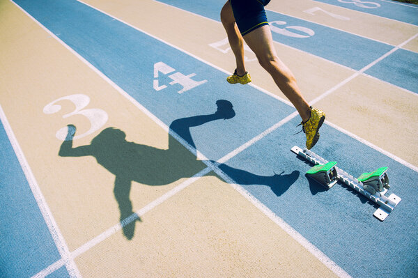 Athlete in Gold Shoes Sprinting Across Starting Line