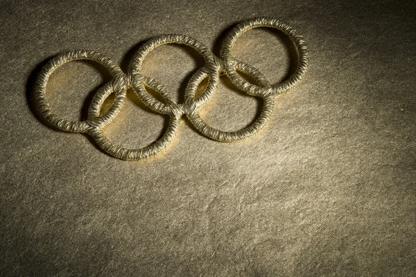 Simbolul inelelor olimpice de aur sub lumina reflectoarelor — Fotografie, imagine de stoc