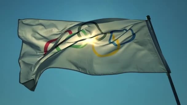 Bandiera Olimpica Sventola nel cielo blu brillante — Video Stock