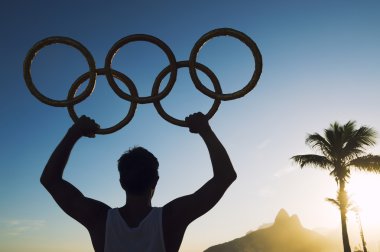 Olimpiyat halkaları Ipanema Plajı günbatımı Rio de Janeiro Brezilya ile sporcu