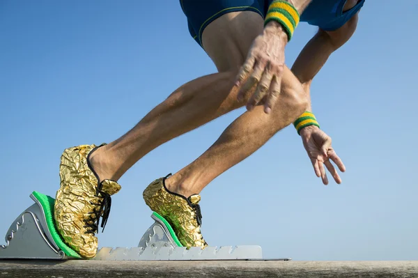 Idrottsman med guld skor börjar en tävling — Stockfoto