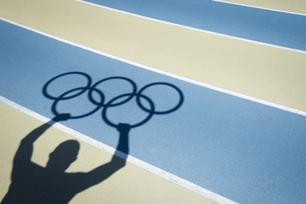 Athlete Holds Olympic Rings Running Track