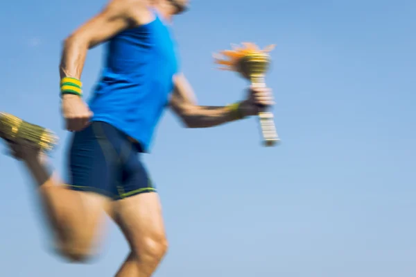 Athlète porteur de flambeau courir avec la torche de sport Ciel bleu — Photo