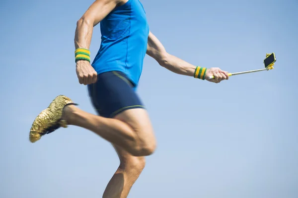 Modern Athlete Running With Smartphone på Selfie Stick – stockfoto