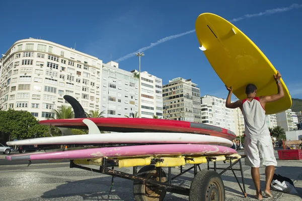 Hombre brasileño descargando tablas de surf Copacabana Rio Brazil — Foto de Stock