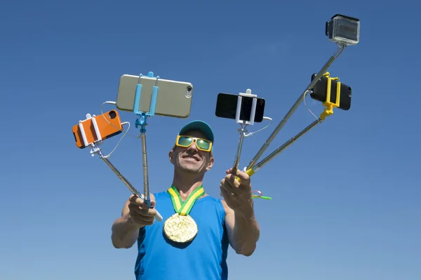 Спортсмен с золотой медалью делает селфи с палками для селфи — стоковое фото