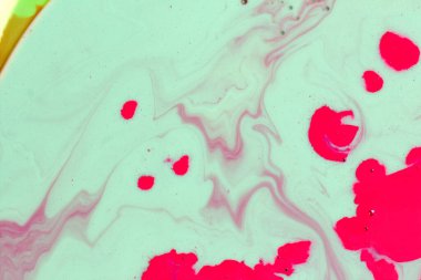 Yeşil zemin üzerinde kestane rengi dalgalar olan kırmızı noktalar