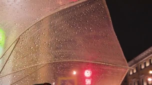 雨の夜の都市のライトから透明傘は水の保護屋外をぼかす — ストック動画