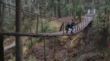 Ormandaki vahşi yolculukta asma köprüdeki fotoğrafçı.
