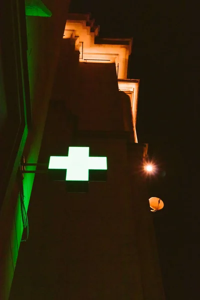 green cross pharmacy on the wall of the building hospital