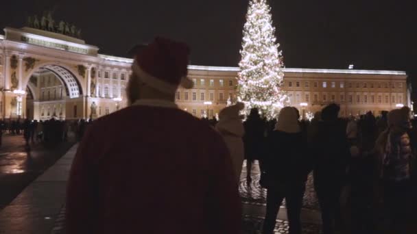 Santa Claus na vánočním stromečku na náměstí vítá lidi zářit světlo nový rok