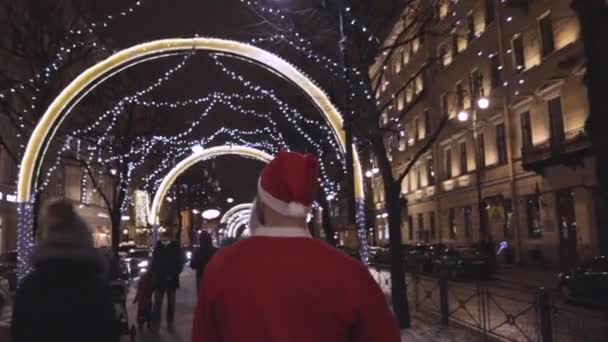 Der Weihnachtsmann Läuft Die Gasse Entlang Und Wünscht Ein Frohes — Stockvideo