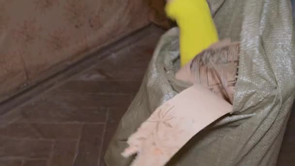 Opruimen bouw puin zak stukken van behang en gips — Stockvideo