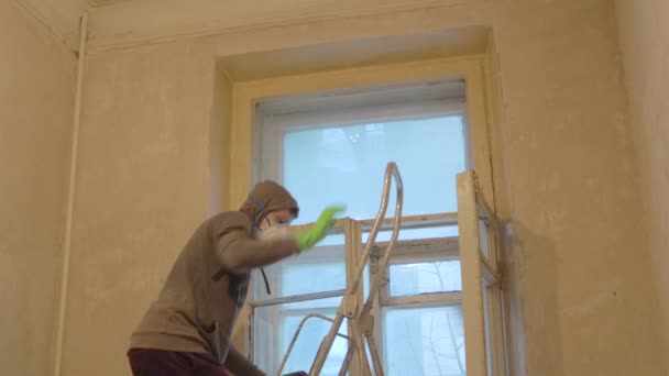 Человек рабочий чистые оконные рамы деревянные в перчатках и маске — стоковое видео