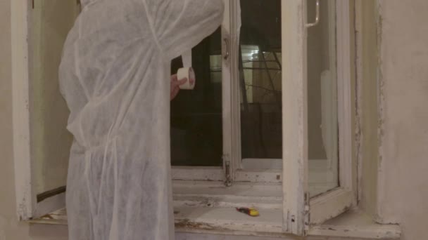 Εργάτης ζωγράφος προετοιμάζει παράθυρο για να ζωγραφίσει ταινία συγκάλυψης — Αρχείο Βίντεο
