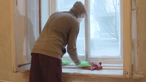 Arbeiter putzen Fensterrahmen mit Handschuhen und Maske — Stockvideo