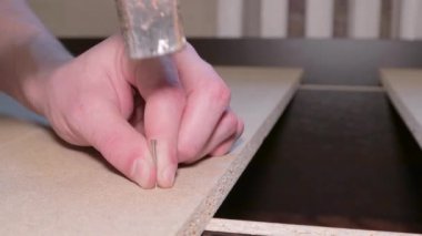 Mobilya montajı yapan marangoz çivi çakma ustası.