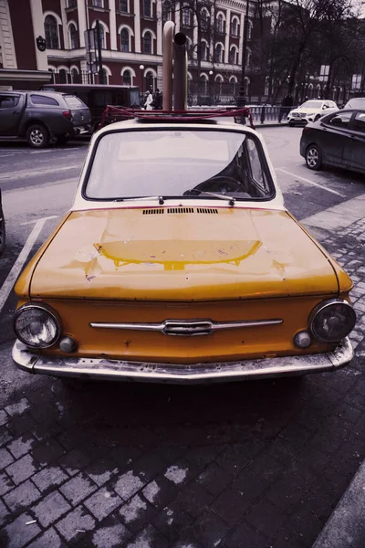 retro car auto yellow on the street of the city small funny vintage