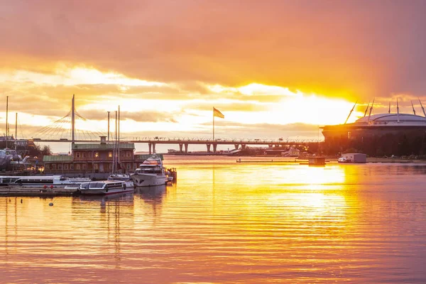 Yat parkı ve St. Petersburg stadyumu. Bulutların hareketli bayrak direği. Gün batımı. Hava değişimi. Turuncu ve pembe renkler..