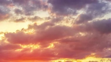 Günbatımı gökyüzü, bulutlar ve güneş ışınları, rüzgar bulutları arasında. Dinamik olarak süzülen bulutlar, 4k zaman dilimi. Konsept hava arkaplanı. Turuncu sarı pembe.