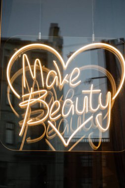 Vitrinde neon tabelalı güzellik salonu makyajı 
